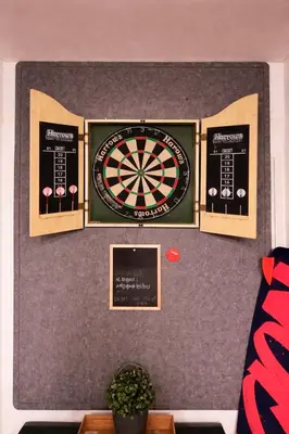 a dart board on a wall with three signs at Modern 1BR Marina 3mins walk to JBR Beach & Tram in Dubai