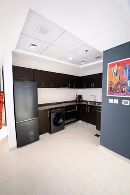 a kitchen with a refrigerator and a dishwasher at Modern 1BR Marina 3mins walk to JBR Beach & Tram in Dubai