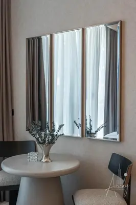 a table with a vase of flowers in front of a mirror at Sunlit Luxe Studio Serene Skies Infinity Pool in Dubai