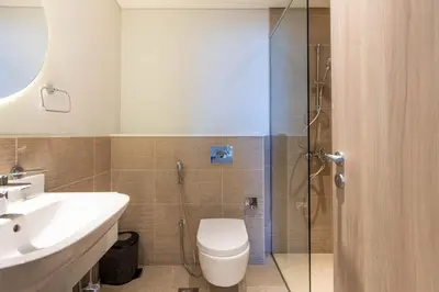 a bathroom with a toilet and a sink and a shower at Luxury 1 Bedroom Sway Residences Dubai Hills in Dubai