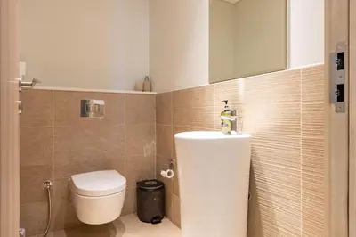 a bathroom with a white toilet and a sink at Luxury 1 Bedroom Sway Residences Dubai Hills in Dubai