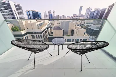 three chairs on a balcony with a view of a city at Luxury Studio Cozy & comfy 12 Min Walk-Dubai Mall in Dubai