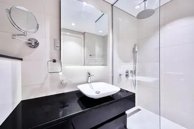 a white bathroom with a sink and a shower at Luxury Studio Cozy & comfy 12 Min Walk-Dubai Mall in Dubai
