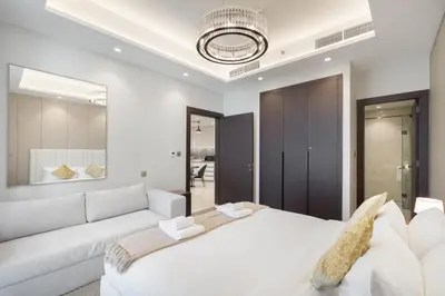 a bedroom with a white bed and a white couch at Luxury 1BR in Nobles Tower - Business Bay Skyline in Dubai