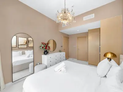 a bedroom with a large white bed and a mirror at Luxury 2BHK with view of Burj Khalifa & Fountain in Dubai