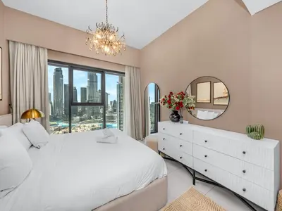 a bedroom with a white bed and a mirror at Luxury 2BHK with view of Burj Khalifa & Fountain in Dubai
