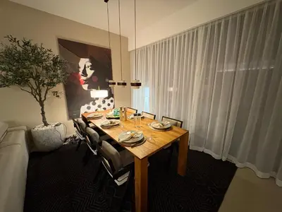 a dining room with a table and a potted tree at Prime Pool Location Spacious Family Villa in Dubai