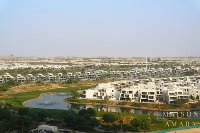 an aerial view of a city with white buildings and a river at Modern Luxury Studio Damac Hills With Golf View in Dubai