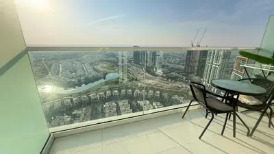 a balcony with a table and chairs on top of a building at Modern Luxury Studio Damac Hills With Golf View in Dubai