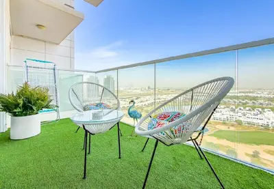 two chairs on a balcony with a view of the city at Serene Golf Course Studio in Artesia Damac Hills in Dubai Marina