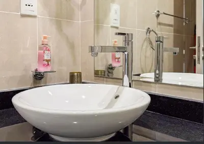 a white sink in a bathroom with a mirror at Serene Golf Course Studio in Artesia Damac Hills in Dubai Marina
