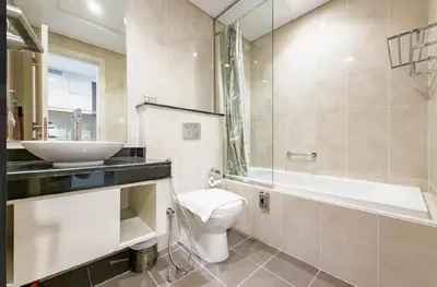 a bathroom with a sink and a toilet and a bath tub at Serene Golf Course Studio in Artesia Damac Hills in Dubai Marina