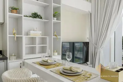 a dining room with a table with plates and glasses at Elegant Studio with Resort Amenities at Miraclez in Dubai