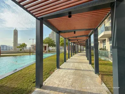 a wooden pergola over a walkway next to a pool at Elegant Studio with Resort Amenities at Miraclez in Dubai
