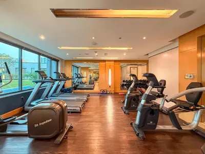 a gym with a row of treadmills and elliptical machines at Elegant 1BR near downtown w Gym Tennis Basketball Courts in Dubai