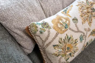 a pillow with flowers on it sitting on a couch at Elegant 1BR near downtown w Gym Tennis Basketball Courts in Dubai