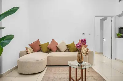 a living room with a couch and a table at Elegant 1BR near downtown w Gym Tennis Basketball Courts in Dubai
