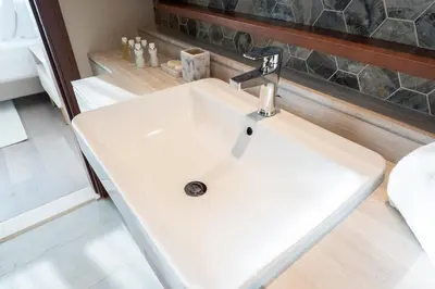 a white bathroom sink with a faucet at Downtown Dubai - Near Burj Khalifa & DWTC-Gulfood - Imperial Avenue in Dubai