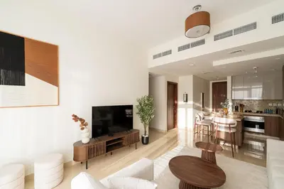 a living room with a couch and a tv and a kitchen at Downtown Dubai - Near Burj Khalifa & DWTC-Gulfood - Imperial Avenue in Dubai