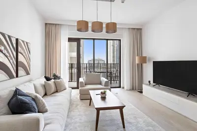a living room with a couch and a tv at Silkhaus Stylish 1BDR with Pool & Balcony Dubai Creek Harbour in Dubai