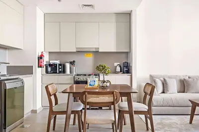a kitchen and dining room with a table and chairs at Silkhaus Stylish 1BDR with Pool & Balcony Dubai Creek Harbour in Dubai