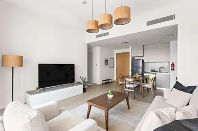 a living room with a couch and a table at Silkhaus Stylish 1BDR with Pool & Balcony Dubai Creek Harbour in Dubai