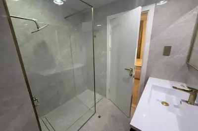 a bathroom with a glass shower and a sink at Heart of Marina with Free Parking, Pool and Gym in Dubai
