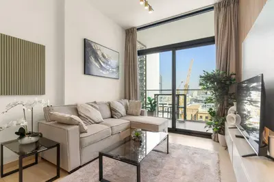 a living room with a couch and a large window at Elegant 1BR Living at Binghatti Emerald in Dubai