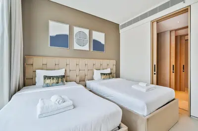 two beds in a bedroom with white sheets at Elegant 3 bed Haven in Address JBR Tower 1 in Dubai