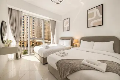 a hotel room with two beds and a window at Trident Grand! Near Beach, Pool and Gym Access! In JBR-Dubai Marina in Dubai