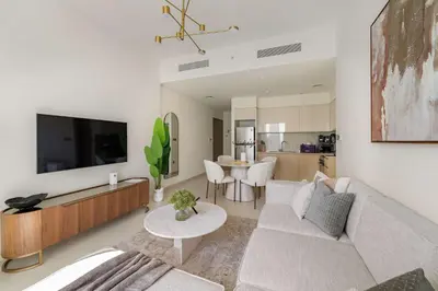 a living room with a couch and a tv and a table at Silkhaus Luxurious 1BR with Balcony Pool and Gym Downtown in Dubai