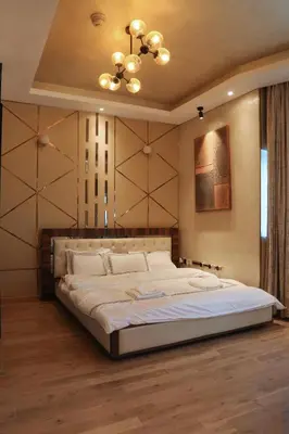a bedroom with a large bed with a chandelier at 902, Royal Residencies, Dubai Sports City in Dubai