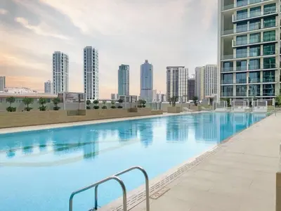 a large swimming pool in a city with tall buildings at GuestReady - Cozy Stay | Near Parks | JVC in Dubai