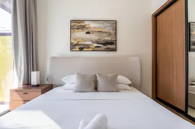 a bedroom with a bed with white sheets and pillows at GuestReady - Cozy Stay | Near Parks | JVC in Dubai