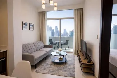 a living room with a couch and a tv and a table at Burj Khalifa View Stylish 1BR in Business Bay in Dubai