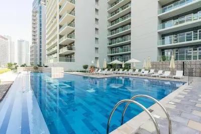 a large blue swimming pool in front of a building at Burj Khalifa View Stylish 1BR in Business Bay in Dubai