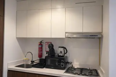 a kitchen with white cabinets and a stove top oven at Burj Khalifa View Stylish 1BR in Business Bay in Dubai