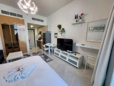a room with a bed and a television and a living room at Skyz by Danube, Brand new Studios in Arjan in Dubai