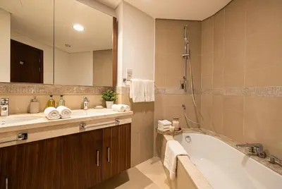 a bathroom with a tub and a sink and a mirror at Burj Vista! Great High Floor View! Mall Connected! Amazing Pool, Gym and Location! in Dubai