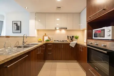 a kitchen with a sink and a microwave at Burj Vista! Great High Floor View! Mall Connected! Amazing Pool, Gym and Location! in Dubai