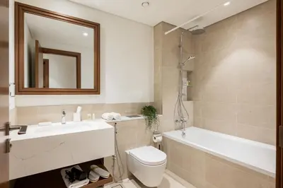 a bathroom with a sink and a toilet and a tub at Beachfront 1BR with Private Beach Access Renovated in Dubai