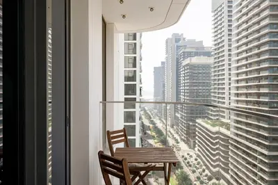 a table and chairs in a window with a view of a city at Beachfront 1BR with Private Beach Access and Balcony in Dubai
