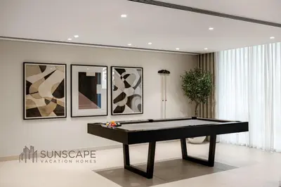a ping pong table in a room with paintings at Beachfront 1BR with Private Beach Access and Balcony in Dubai