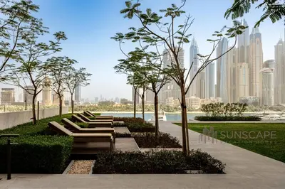 a park with benches and trees in front of a city at Beachfront 1BR with Private Beach Access and Balcony in Dubai