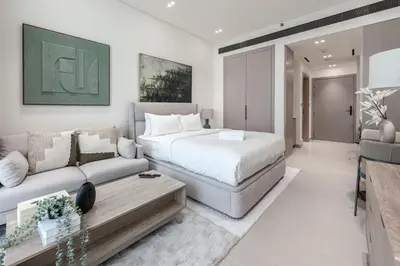a bedroom with a bed and a couch at Modern and Serene Studio - JVC in Dubai