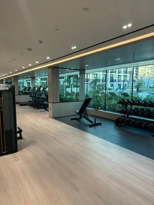 a room with a gym with chairs and windows at Modern and Serene Studio - JVC in Dubai