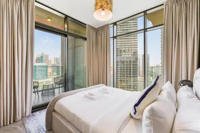 a bedroom with a bed and a large window at Modern 2Bed with Iconic Burj Khalifa & Canal Views in Dubai