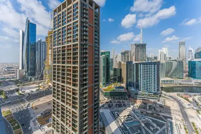 a tall building in the middle of a city at Modern 2Bed with Iconic Burj Khalifa & Canal Views in Dubai