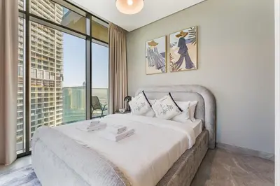 a bedroom with a large bed with a large window at Modern 2Bed with Iconic Burj Khalifa & Canal Views in Dubai