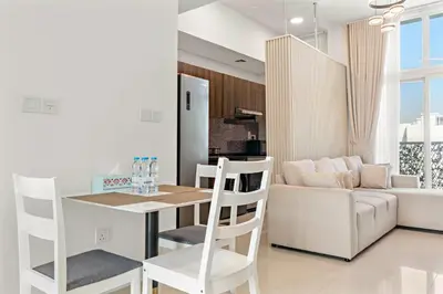 a kitchen and living room with a table and a couch at Stylish Community 2BR Avencia 2,DAMAC Hills-2 in Dubai